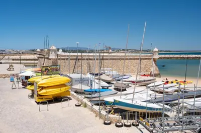 a group of boats are docked on a beach at Porto de Mós 85 by Destination Algarve in Lagos