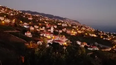 a town on a hill at night at Apartamento Villa in Ponta do Sol