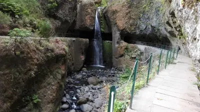 a waterfall on the side of a mountain with a creek at Apartamento Villa in Ponta do Sol