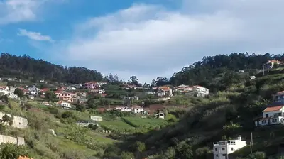 a village on the side of a hill with houses at Apartamento Villa in Ponta do Sol
