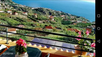 a view of the ocean from a balcony of a house at Apartamento Villa in Ponta do Sol