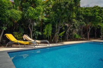 a swimming pool with two chairs and a yellow chair next to it at Casa da Cal - by Casas na Ilha in Câmara de Lobos