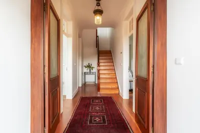 a hallway with wooden floors and a staircase with a rug at Casa da Cal - by Casas na Ilha in Câmara de Lobos