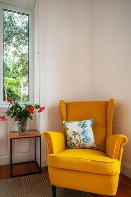 a yellow chair with a pillow in a room with a window at Casa da Cal - by Casas na Ilha in Câmara de Lobos