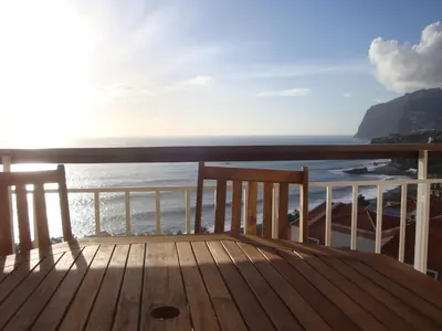 a wooden deck with a view of the ocean at Listen the sound of the Sea - The Sunset of your Dreams in Funchal