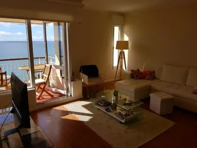 a living room with a couch and a view of the ocean at Listen the sound of the Sea - The Sunset of your Dreams in Funchal
