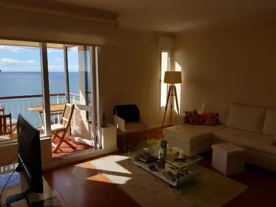 a living room with a couch and a view of the ocean at Listen the sound of the Sea - The Sunset of your Dreams in Funchal