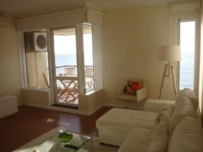 a living room with a couch and a view of the ocean at Listen the sound of the Sea - The Sunset of your Dreams in Funchal