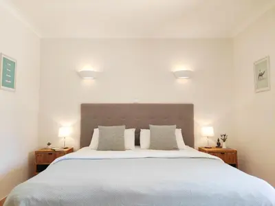 a bedroom with a large white bed with two lamps at Casa Canavial in Luz