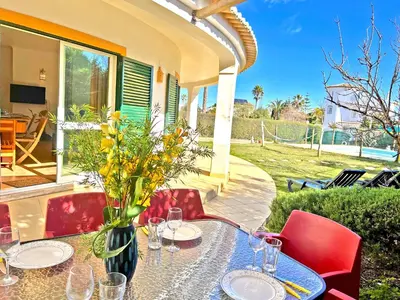 a table with glasses and a vase with flowers on it at Private Villa Rego with Oceanview and Pool in Luz