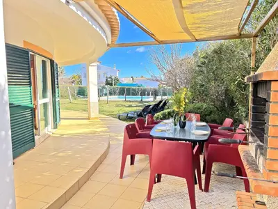 a patio with red chairs and a black table and chairs at Private Villa Rego with Oceanview and Pool in Luz