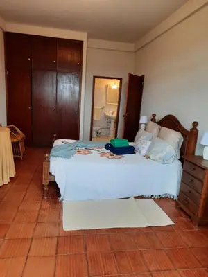 a bedroom with a white bed and a mirror at Quintinha das Lombas in Porto Santo