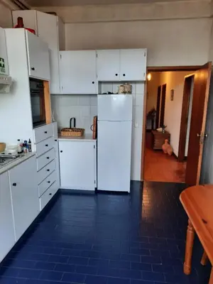 a kitchen with white cabinets and a blue tile floor at Quintinha das Lombas in Porto Santo