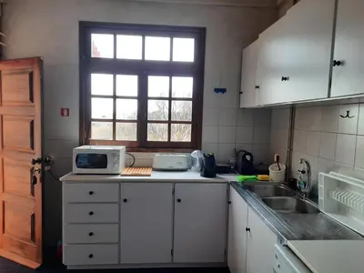 a kitchen with white cabinets and a sink and a window at Quintinha das Lombas in Porto Santo