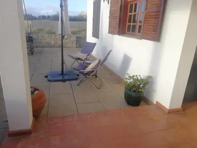 a patio with two chairs and an umbrella at Quintinha das Lombas in Porto Santo