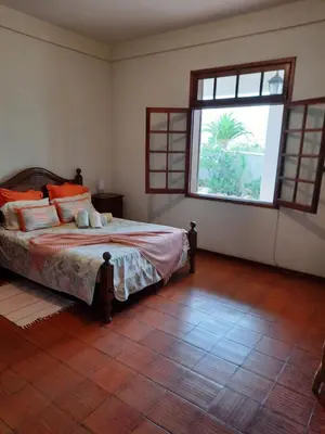 a bedroom with a bed and a large window at Quintinha das Lombas in Porto Santo