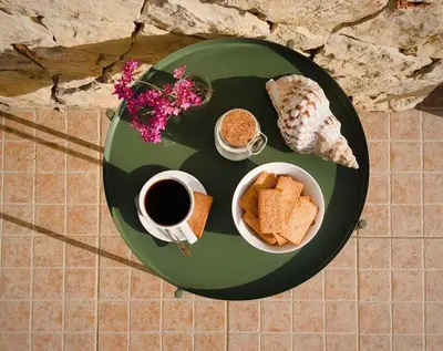 a green plate with bread and a cup of coffee and a plate with a breakfast at Endless Summer Surf House in Aljezur