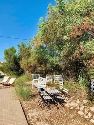 a table and chairs sitting next to a tree at Endless Summer Surf House in Aljezur
