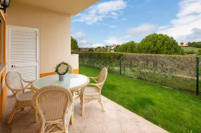 a patio with a table and chairs and a green yard at Luxury apartment with free use of pool, gym and spa in Lagos