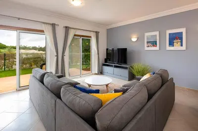 a living room with a large couch and a television at Luxury apartment with free use of pool, gym and spa in Lagos