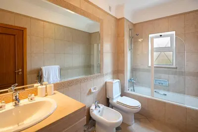 a bathroom with a sink and a toilet and a mirror at Luxury apartment with free use of pool, gym and spa in Lagos
