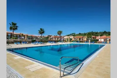 a swimming pool at a resort with chairs and palm trees at Luxury apartment with free use of pool, gym and spa in Lagos