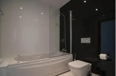 a bathroom with a tub and a toilet and a sink at ZENTUNI Ocean front in Lagos
