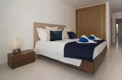 a bedroom with a large bed with blue pillows at ZENTUNI Ocean front in Lagos