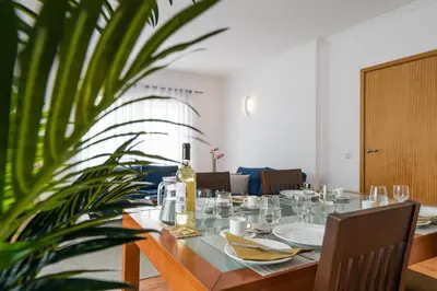 a dining room with a table and a plant at Two Bedroom Apartment Vila Mos Lagos in Porto de Mós