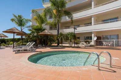 a swimming pool in front of a hotel at Two Bedroom Apartment Vila Mos Lagos in Porto de Mós