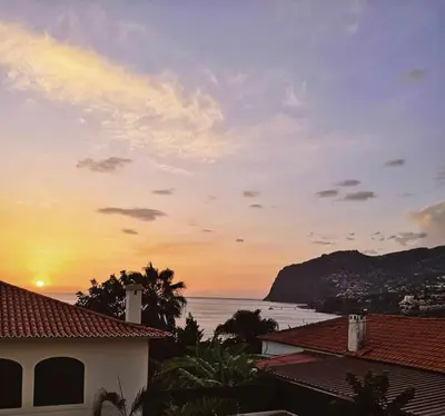 a sunset view of the ocean from a house at Madeira - Sunset Sea View of Cabo Girão in Funchal