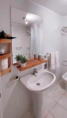 a white bathroom with a sink and a mirror at Madeira - Sunset Sea View of Cabo Girão in Funchal