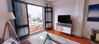 a living room with a television and a large window at Madeira - Sunset Sea View of Cabo Girão in Funchal