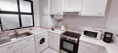 a white kitchen with a sink and a microwave at Madeira - Sunset Sea View of Cabo Girão in Funchal