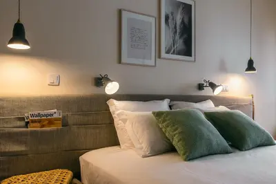 a bedroom with a bed with two lights on it at Three House Hotel in Funchal