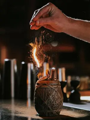 a person is holding a fire coming out of a vase at Three House Hotel in Funchal