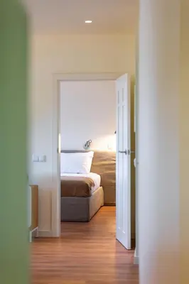 a bedroom with a bed and an open door at Three House Hotel in Funchal