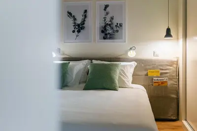 a bedroom with a bed with white and green pillows at Three House Hotel in Funchal