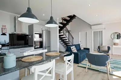 a kitchen and living room with a table and chairs at Vilas Felicidade Rocha by An Island Apart in Ponta do Pargo