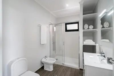 a white bathroom with a toilet and a shower at Vilas Felicidade Rocha by An Island Apart in Ponta do Pargo