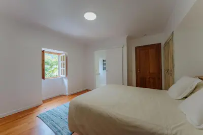 a bedroom with a large bed and a window at Madeira Surf Lodge in São Vicente