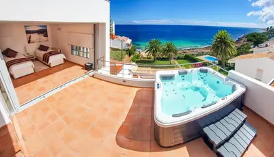 a hot tub on the balcony of a house at The Fantastic Beach House of Luz in Luz