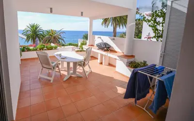 a patio with a table and chairs and the ocean at The Fantastic Beach House of Luz in Luz