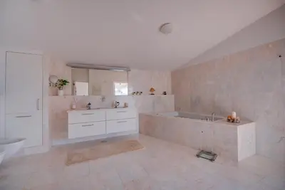 a large bathroom with a tub and a sink at The Fantastic Beach House of Luz in Luz
