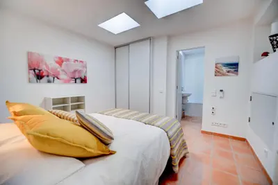 a bedroom with a white couch with yellow pillows at The Fantastic Beach House of Luz in Luz