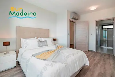 a bedroom with a bed and a sign on the wall at OurMadeira - Casa Amaro Sunset in Calheta