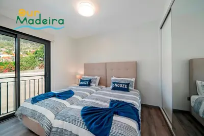 two beds in a bedroom with a balcony at OurMadeira - Casa Amaro Sunset in Calheta