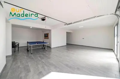 an empty room with a ping pong table in the middle at OurMadeira - Casa Amaro Sunset in Calheta