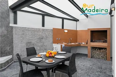 a dining room and kitchen with a table and chairs at OurMadeira - Casa Amaro Sunset in Calheta