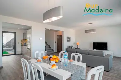 a living room with a table and a couch at OurMadeira - Casa Amaro Sunset in Calheta